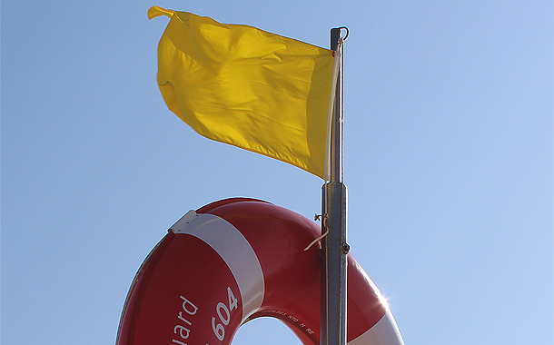Gele vlag op het strand van Portugal