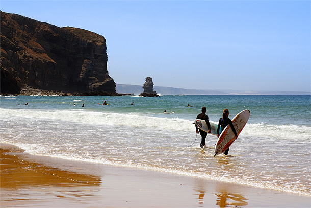 Surfers bij Praia da Arrifana, Aljezur, Algarve.
