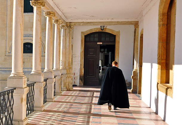 Student van de universiteit van Coimbra in traditionele zwarte mantel